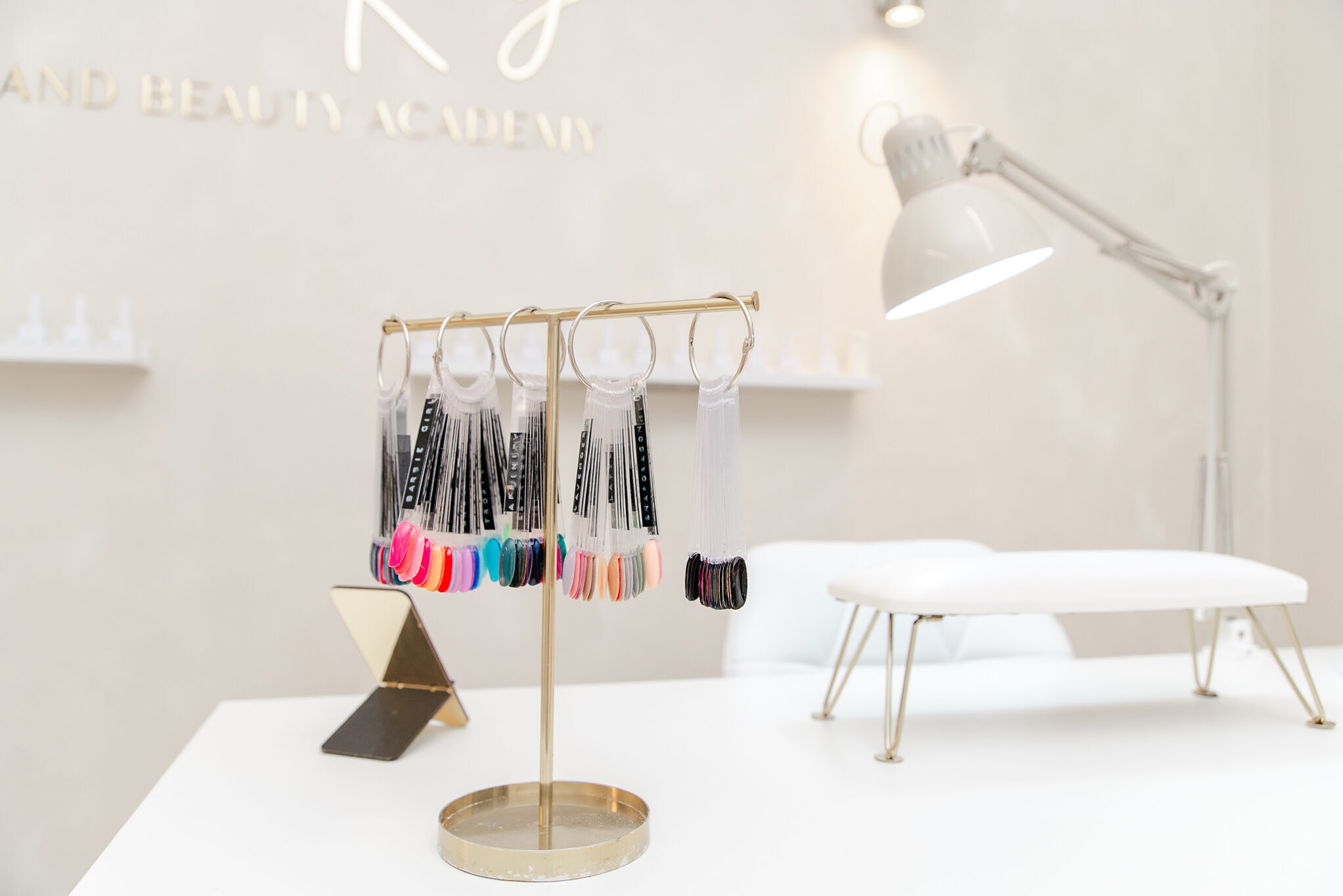 Nail technicians desk displaying all different colours of nail polishes available. Bright and neutral space, friendly and welcoming.